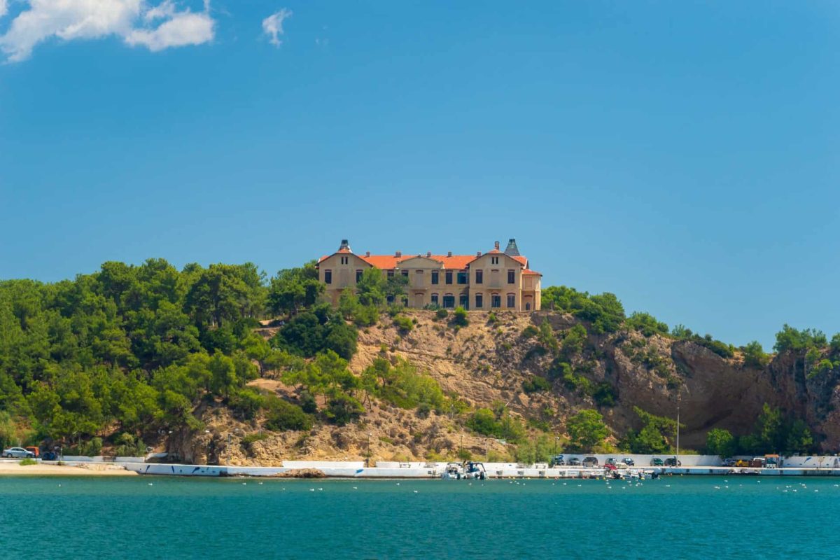 Ιστορικό κτίριο της Θάσου χτισμένο πάνω σε λόφο με θέα στη θάλασσα.